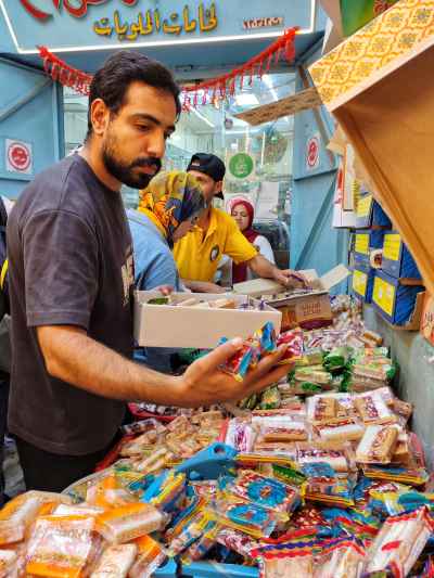 Man Selecting Moulid Candy at Bein El-Haraet Market, Cairo