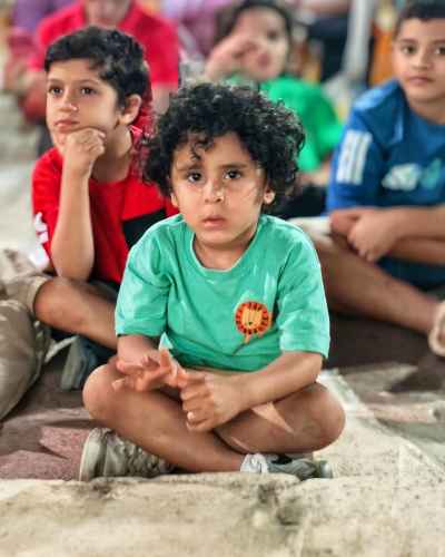 Egyptian Children Sitting Attentively at Outdoor Event
