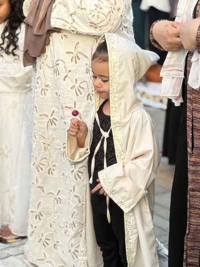 Toddler Girl in Eid Abaya Holding a Lollipop