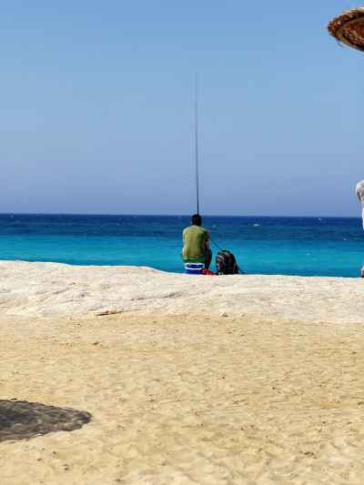 Fisherman Surf Fishing on North Coast Beach, Alexandria