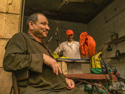 Egyptian Man Laughing in Traditional Ironing Shop, Cairo