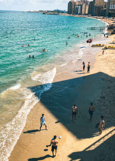 Men Playing Football on Alexandria Sandy Beach