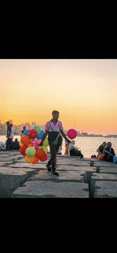 Balloon Vendor Walking Alexandria Corniche at Sunset