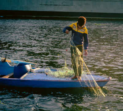Fisherman Casting Net from Boat, Al-Qanater Al-Khayreya
