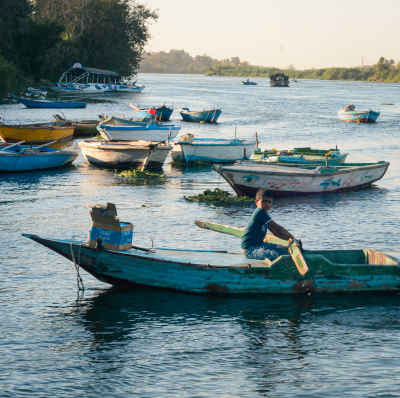 Fisherman Rowing Wooden Boat, Al-Qanater Al-Khayriyya