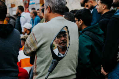 Local Football Spectator Reflected in a Motorcycle Mirror During Al Falaki Tournament