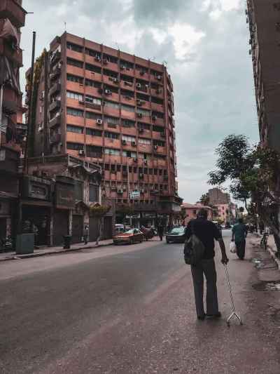 Elderly Man Walking Downtown Cairo Street, Egypt