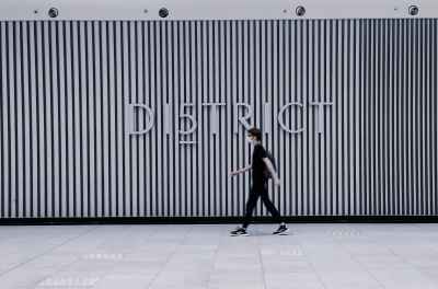 Person Walking Past District 5 Mall Facade, Cairo