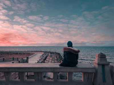 Person Sitting on Seafront Railing at Sunset, Alexandria