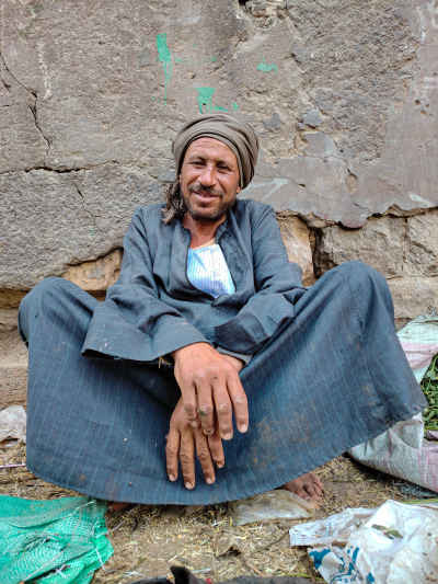 Upper Egyptian Vendor Sitting on the Sidewalk in a Local Market