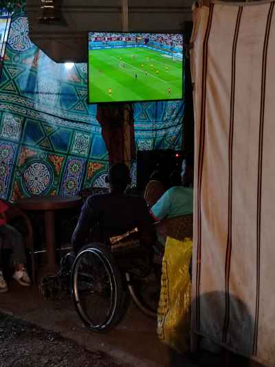 Wheelchair Fan & Foreign Residents in Egypt Watching World Cup Match at Local Café