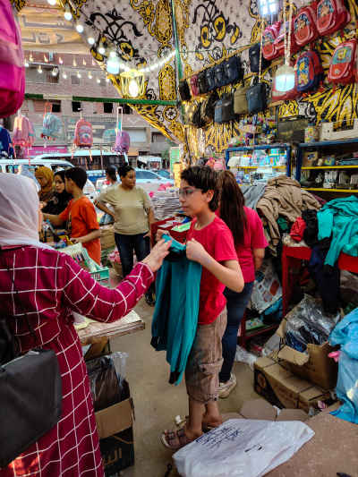 Boy Trying On School Uniform at Cairo Market Stall