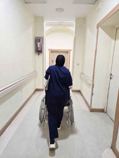 Nurse Pushing Wheelchair in Hospital Corridor, Cairo