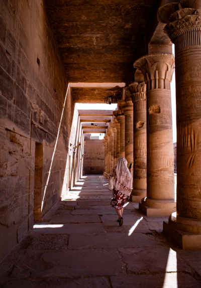 Woman Walking Through Philae Temple Colonnade Aswan