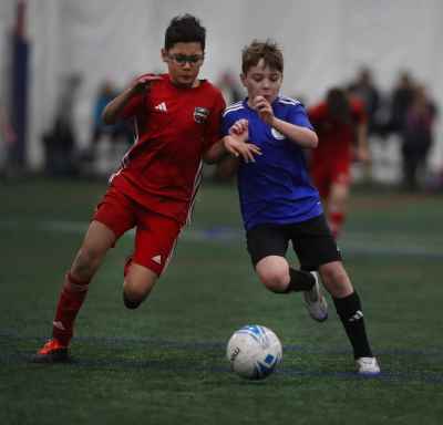 Boys Competing for Ball in Indoor Youth Soccer Match