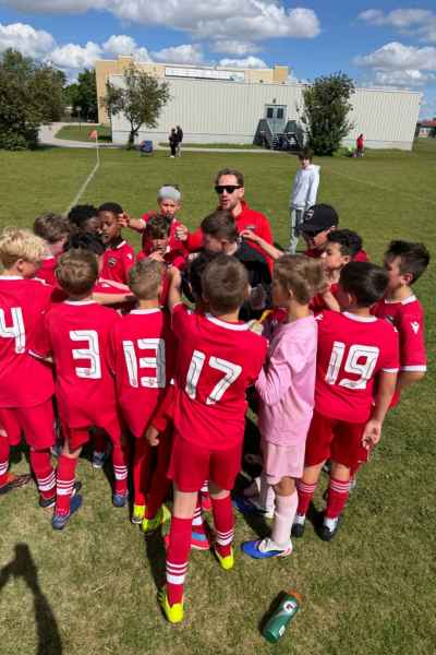 Youth Soccer Team Huddle with Coach Outdoors