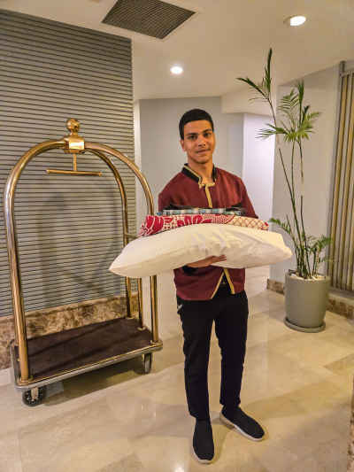 Hotel Bellboy Carrying Pillows in Cairo Hotel Lobby
