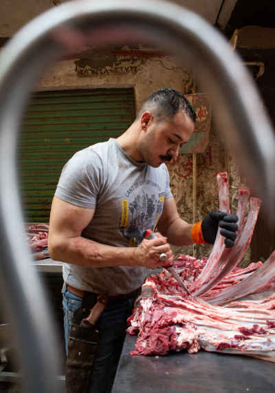 Traditional Egyptian Butcher Cutting Meat in Old Cairo Market