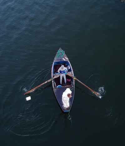 Two Fishermen Rowing Small Boat on Nile River Qena
