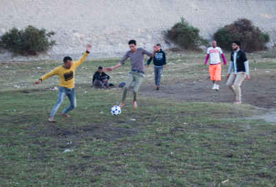 Players Compete for the Ball in a Community Football Match