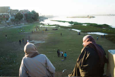 Spectators Watch a Community Football Match Along the Nile