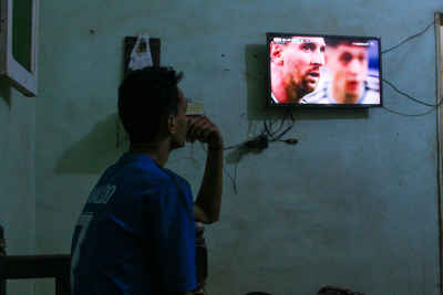 Football Fan Watching a Match on Television at Home