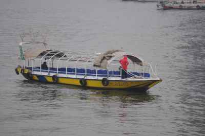 A boat in the middle of the Nile with a woman standing on it, enjoying the view of the river and the surrounding cityscape.