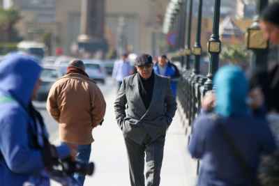 A man in a suit walking on Kasr el Nil Bridge during Eid