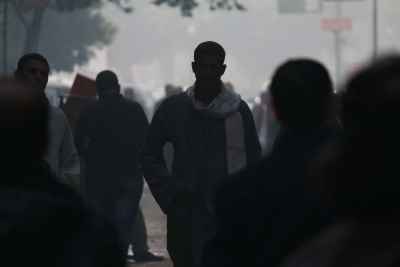 A young man in traditional Egyptian attire walks through a crowded