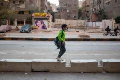 Schoolboy Walking on Road Median, Sudan Street Cairo