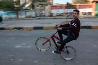 Young Man Riding Red Bicycle on Sudan Street Cairo