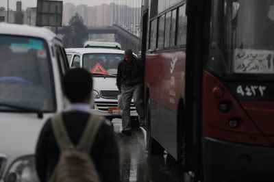Cairo Commuters and City Bus in Rainy Traffic