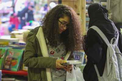 Curly-Haired Girl Reading a Book at Cairo International Book Fair 2017