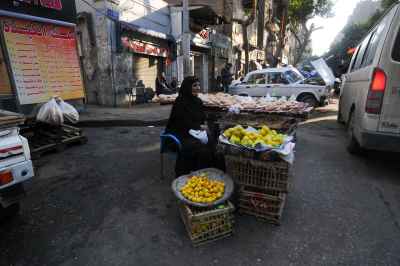 Elderly Woman Selling Traditional Bread and Lemons