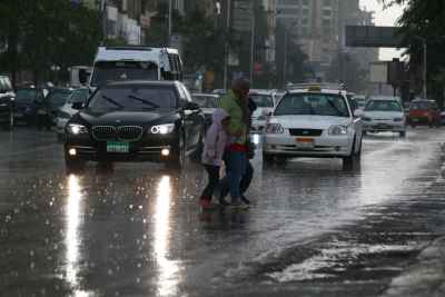 Family Crossing the Street on a Rainy Day in Cairo 1