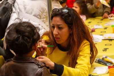 Woman Face Painting Child at Cairo Community Event