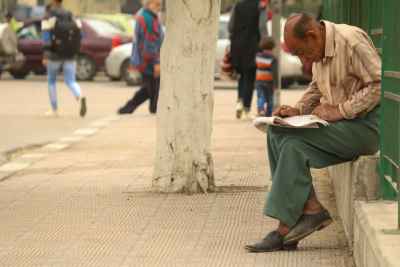Man Reading a Newspaper in a Street in Cairo, Egypt 4