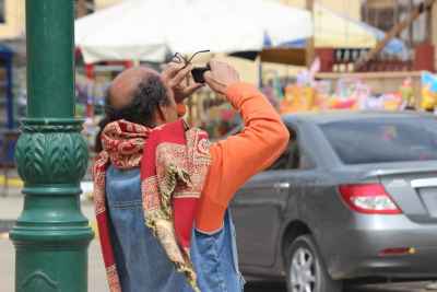 Man Taking a Mobile Photo in Cairo Street Scene