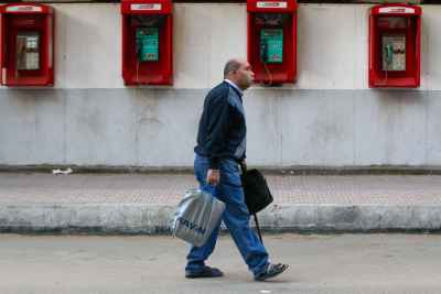 Man Walking on Mohamed Mahmoud Street in Front of the Telephone Booths