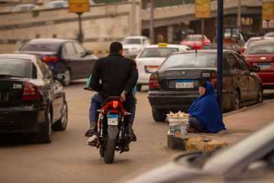 Motorcycle Passing a Street Vendor in Cairo Traffic