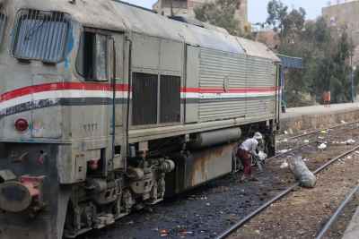 Railway Worker Cleaning Tracks Beside Train in Cairo