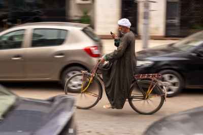 Saidi Man Riding a Bicycle While Using a Mobile Phone in Cairo