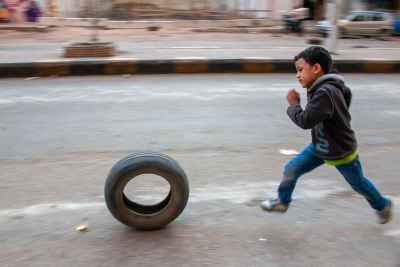 Boy Running with Tire, Sudan Street Cairo