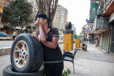 Boy Leaning on Car Tires, Sudan Street Cairo