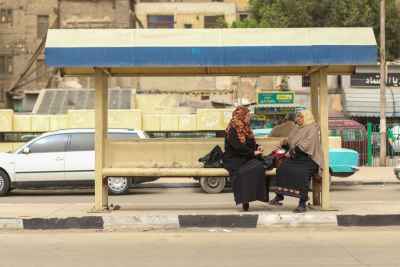 Two Women Sitting and Waiting for the Bus at a Station in Cairo