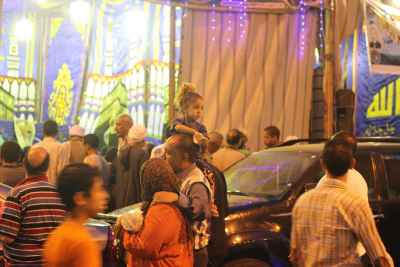 Women Carrying Children on Their Shoulders During Festive Mawlid Celebration – Cairo, Egypt 1