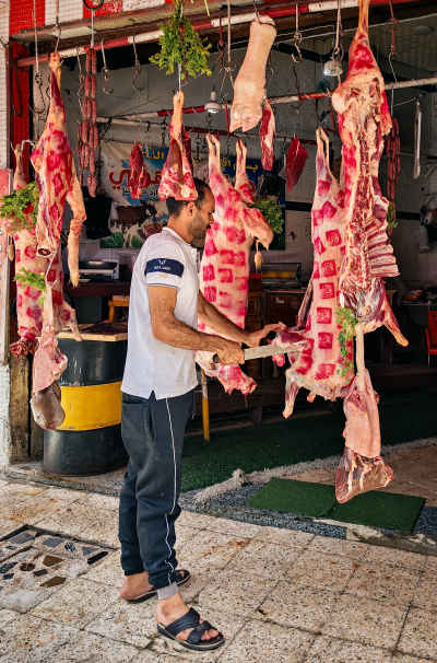 Egyptian Butcher Cutting Hanging Meat Before Eid al-Adha