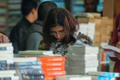 Young Woman Browsing Books at Cairo International Book Fair 2017