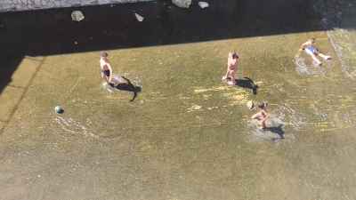 Children Playing Football in Shallow Water Near Al-Qanater