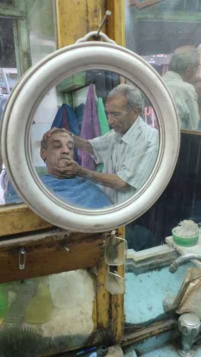 Traditional Egyptian Barber Reflected in Round Mirror